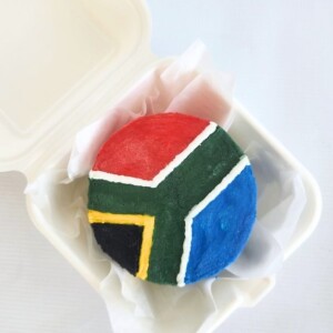 A South African flagged Lunchbox cake created by OhMyCake with a top view.