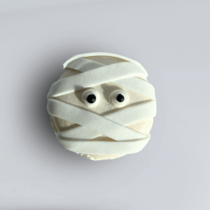 Creepy Crawly Cookie Halloween treat featuring a white cupcake wrapped in icing bandages with two black eyes