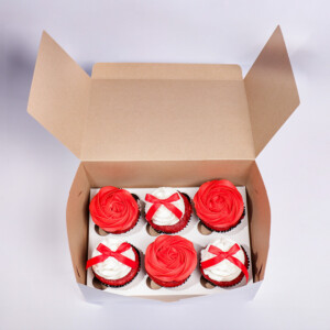 Ribbons and Roses cupcakes set of six in a brown cardboard box, each topped with red rose-shaped frosting and decorated with a red ribbon bow. 1