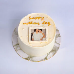 Mini Mom's Flower Pot Cake with white frosting, yellow message icing, and a framed mother-and-child photo displayed on top of the cake